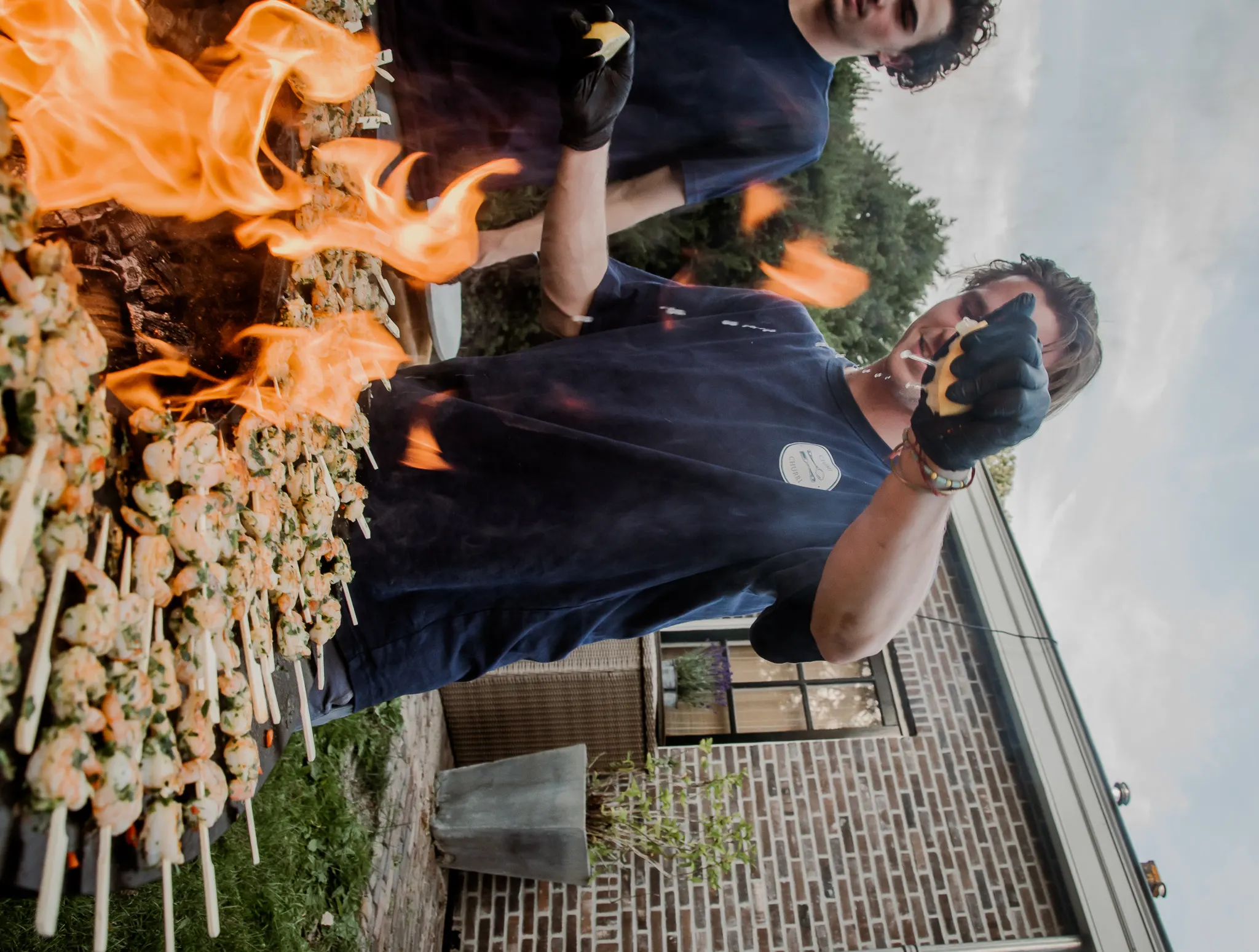 Chefs flame-grilling skewers at a Chimi & Churri event