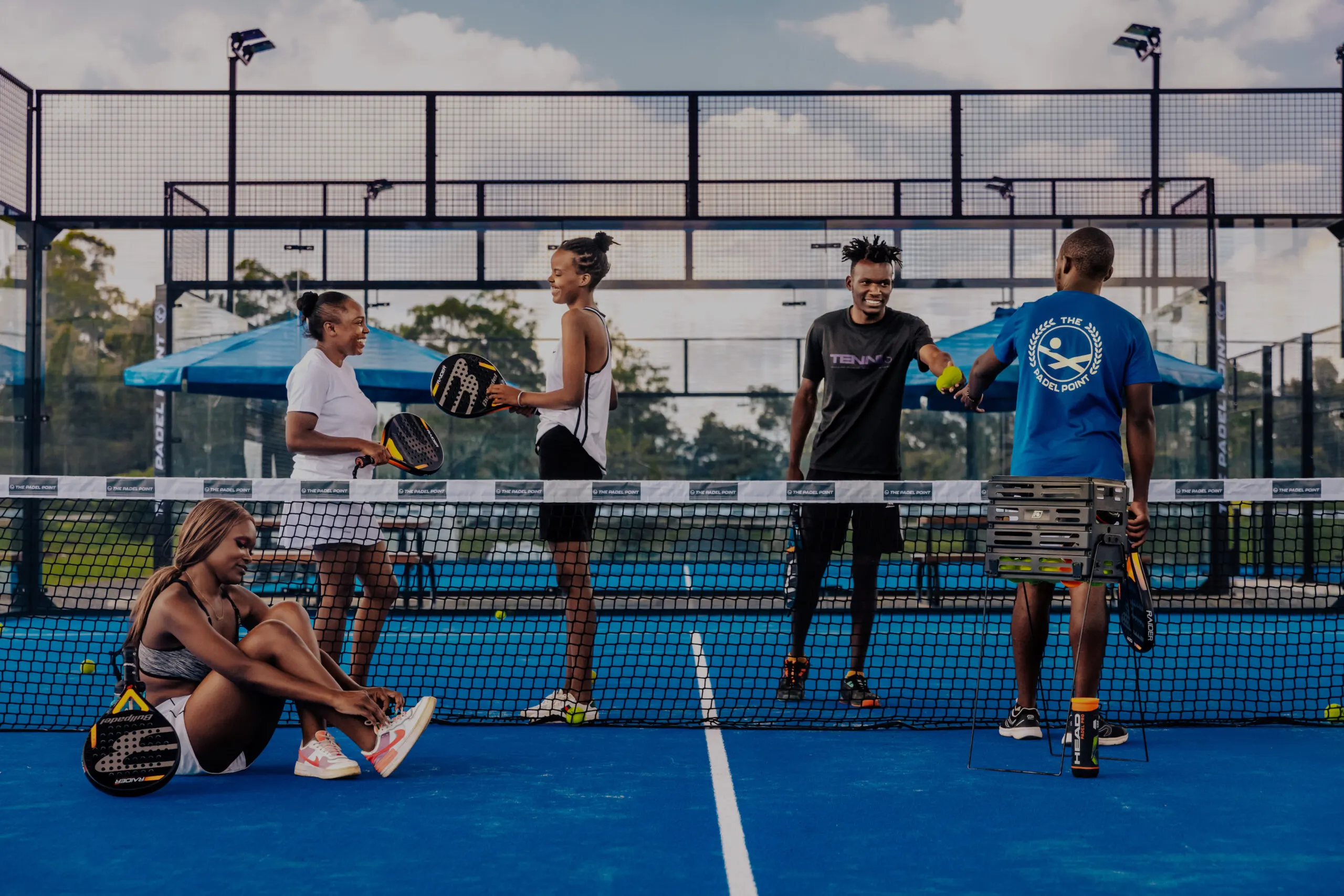 Players chatting on a blue padel court at The Padel Point Kenya